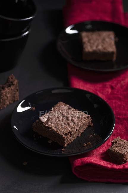 Brownies serving on black plates — Stock Photo