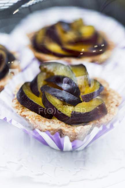 Plum tartlets in paper cases — Stock Photo