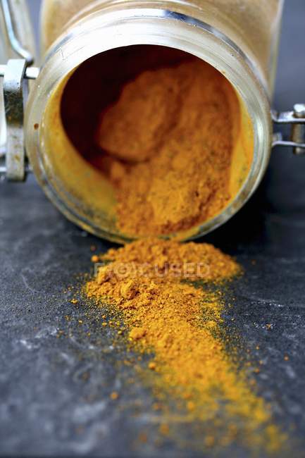 Turmeric powder in upturned jar — Stock Photo
