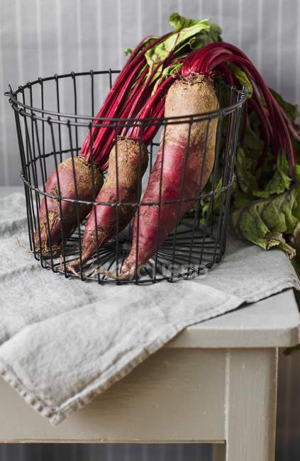Fresh Beetroot with leaves in wire basket — Stock Photo