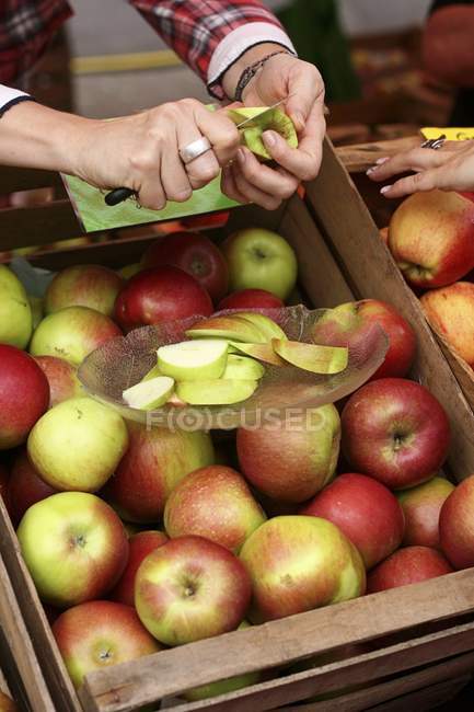 Женские руки режут яблоки — стоковое фото