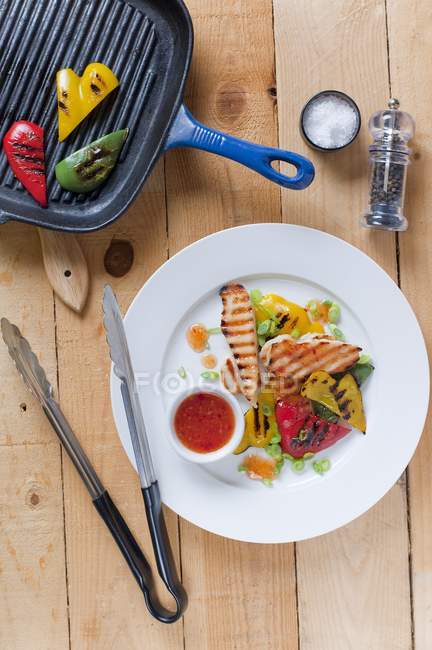 Top view of grilled chicken breast and peppers with chilli sauce — Stock Photo