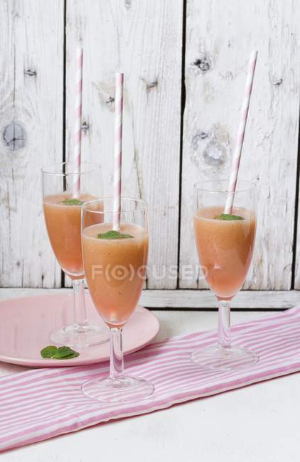Three rhubarb drinks with straws in glasses — Stock Photo