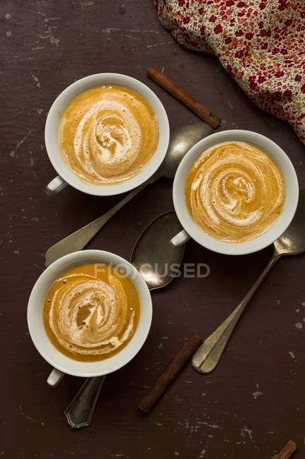 Top view of three cups of apricot soup with cinnamon — Stock Photo