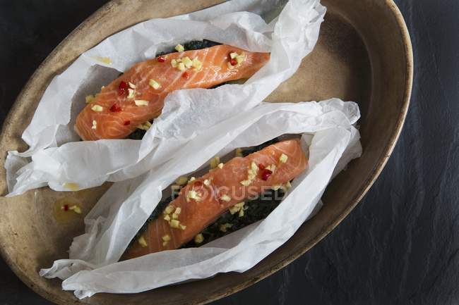 Raw salmon fillets in paper — Stock Photo