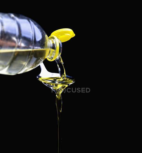 Nahaufnahme des Einfüllens von Öl aus einer Plastikflasche in einen Löffel — Stockfoto