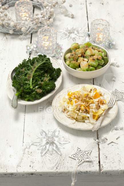 Vue rapprochée de trois plats de légumes et décorations de Noël — Photo de stock