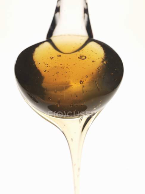 Spoonful of honey on white — Stock Photo