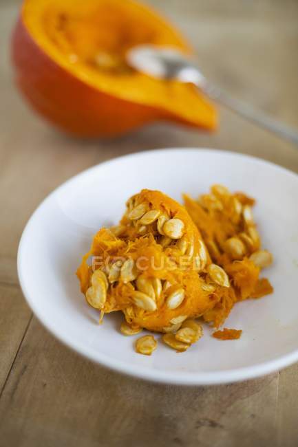 Seeds and fruit pulp from a Hokkaido pumpkin  on white plate — Stock Photo