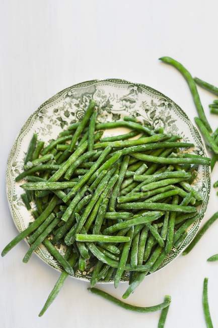 Plate of frozen green beans — Stock Photo