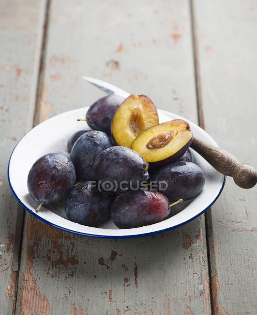 Fresh whole and halved damsons — Stock Photo