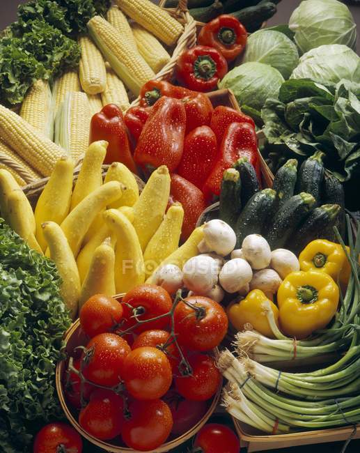 Verduras frescas, mazorcas de maíz y lechuga en un mercado - foto de stock