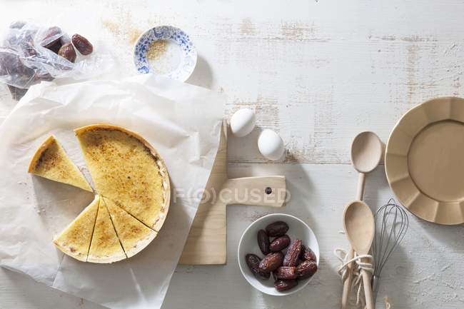 Crme brle tart com datas sobre a superfície branca com tábua de corte — Fotografia de Stock