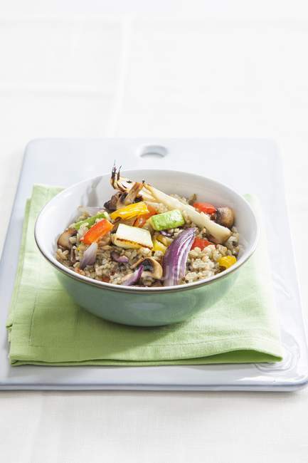 Freekeh with colourful roasted vegetables in bowl over towel — Stock Photo