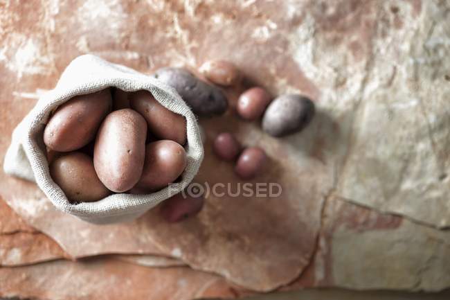 Red and purple potatoes in linen sack — Stock Photo