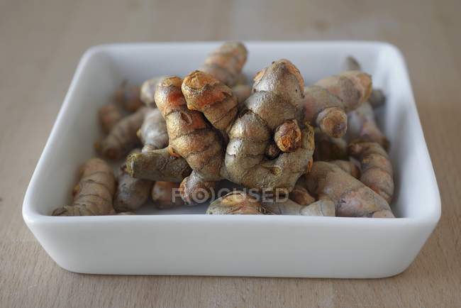 Turmeric roots in porcelain dish — Stock Photo