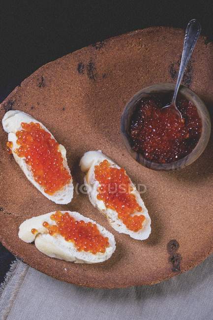 Rodajas de baguette rematadas con caviar rojo - foto de stock