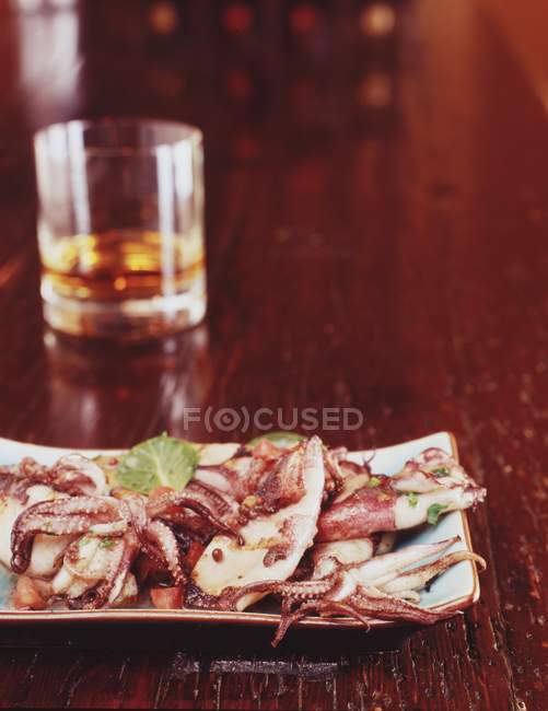 Grilled squid and a glass Scotch — Stock Photo