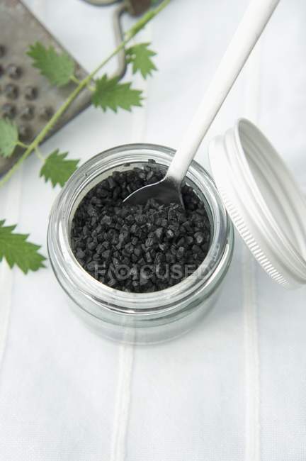Sal preto em um jarro de topo de parafuso — Fotografia de Stock