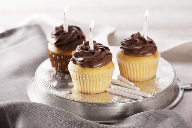 Cupcakes de cumpleaños con velas encendidas - foto de stock