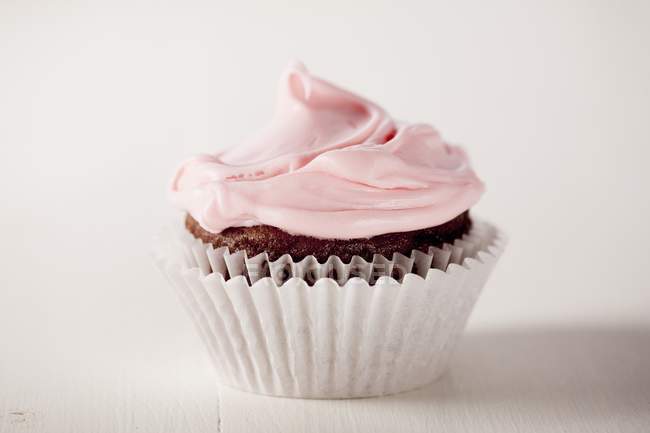Cupcake rematado con glaseado rosa - foto de stock