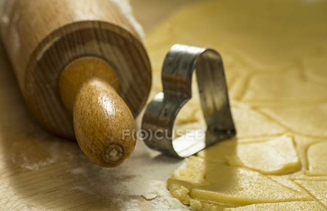 Closeup view of rolling pin with a cutter and biscuit pastry — Stock Photo
