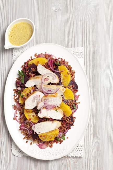 Buchweizen-Rote-Bete-Salat mit Orangen und gegrillter Hühnerbrust auf weißem Teller — Stockfoto