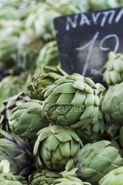 Alcachofas frescas con tabla de precios - foto de stock