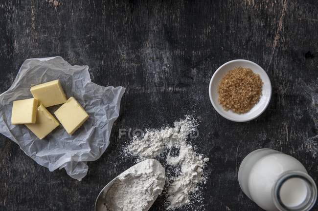 Top view of various baking ingredients on dark wooden surface — Stock Photo