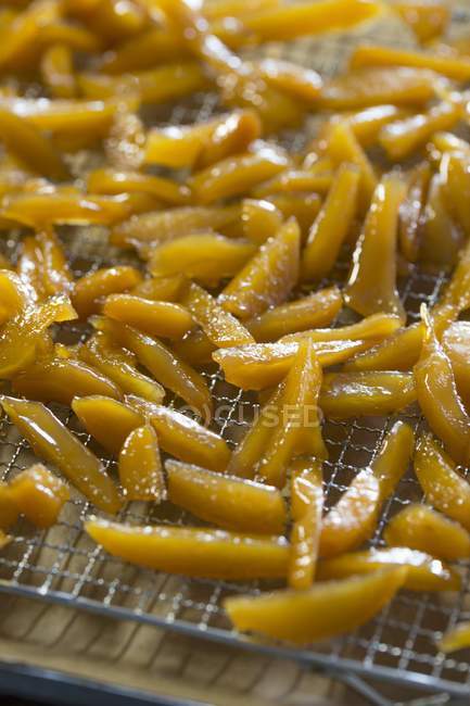 Closeup view of candied ginger sticks drying on a rack — Stock Photo