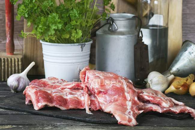 Raw pork ribs with vegetables and parsley — Stock Photo