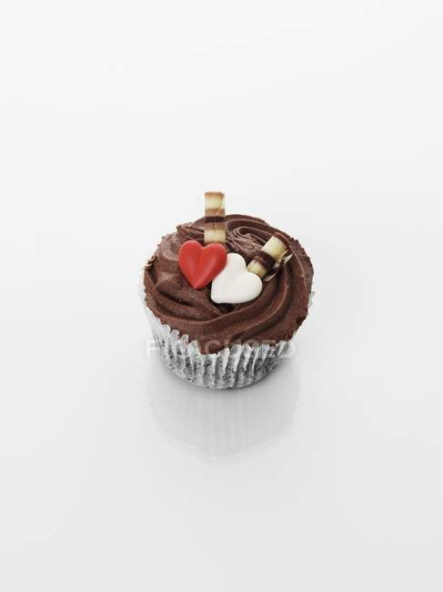 Cupcake decorated with chocolate cream and hearts — Stock Photo