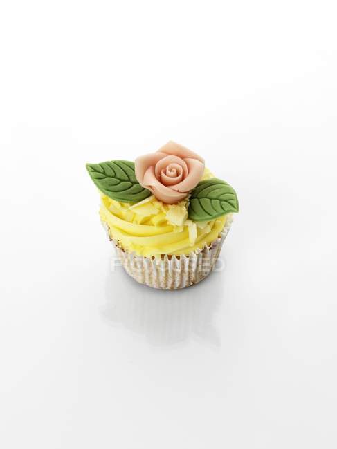 Cupcake decorated with marzipan rose — Stock Photo