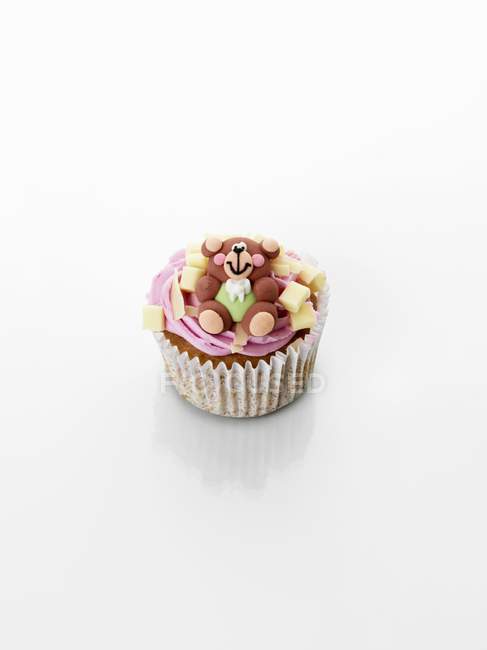 Cupcake décoré de crème et ours en peluche — Photo de stock