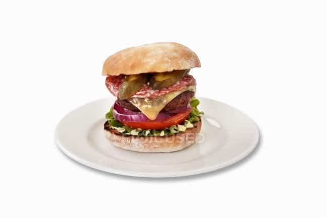 Cheeseburger with salami and gherkins — Stock Photo