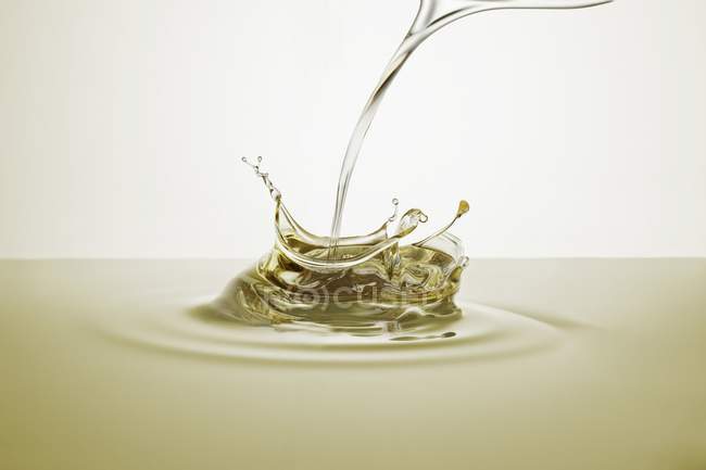 Closeup view of a splash of pouring oil — Stock Photo