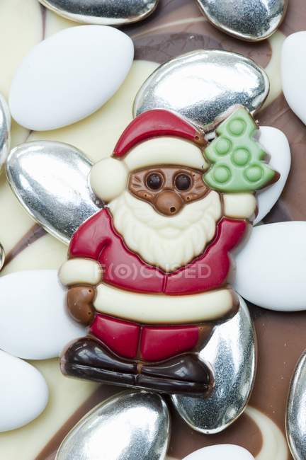 Closeup view of chocolate Santa Claus on sugared almonds — Stock Photo
