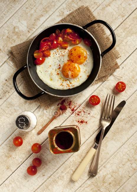 Fried eggs and chopped tomatoes — Stock Photo