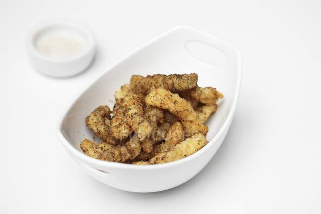 Closeup view of crispy chicken strips in white bowl — Stock Photo