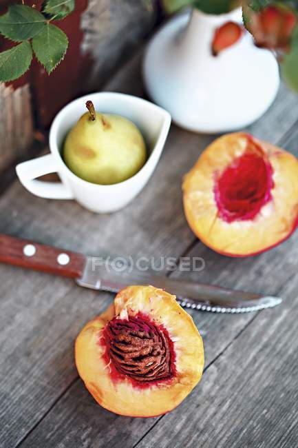 Frische Pfirsiche und Birnen im Becher — Stockfoto