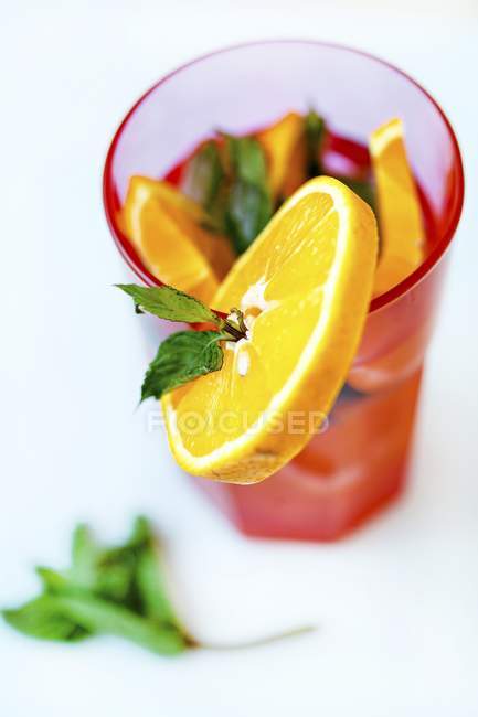 Vista de primer plano de la bebida con menta y naranja - foto de stock