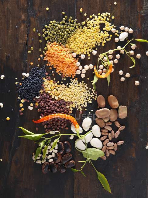 Assorted pulses over dark wooden surface — Stock Photo