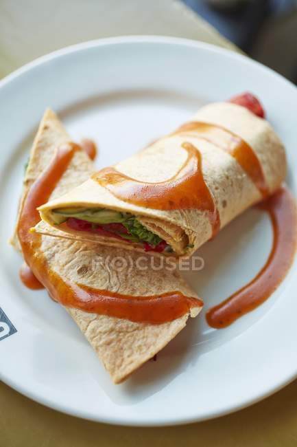 Tortillas filled with vegetables with tomato sauce on white plate — Stock Photo