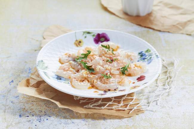 Carpaccio di gamberi con aglio, pepe e rucola su piatto bianco — Foto stock