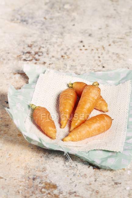 Baby carrots on piece of paper — Stock Photo