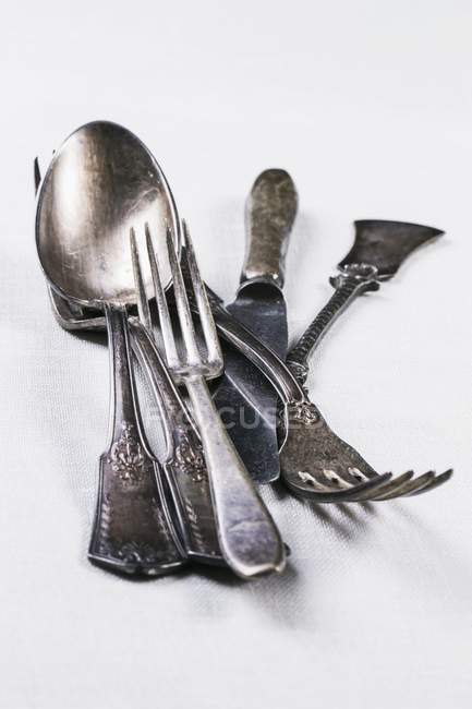 Closeup view of old silver cutlery on a white  surface — Stock Photo