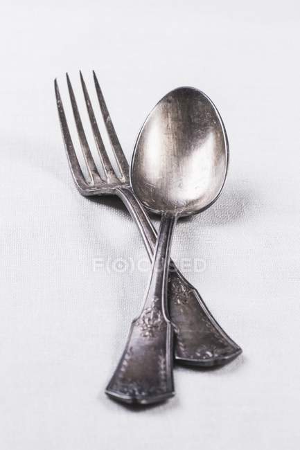 Closeup view of old silver spoon and fork on white surface — Stock Photo