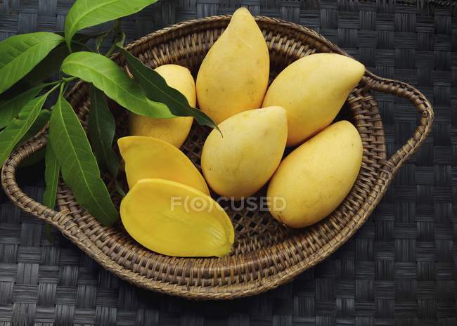 Жовті манго в кошику — стокове фото