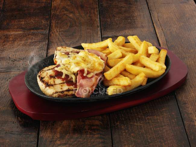 Chicken with bacon over wooden — Stock Photo