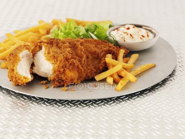 Closeup view of hot and spicy chicken breast with chips, salad and mayonnaise — Stock Photo